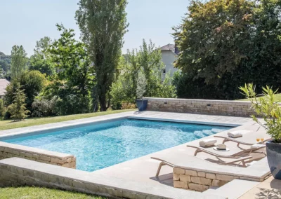 Piscine murets pierres et plage en surplomb