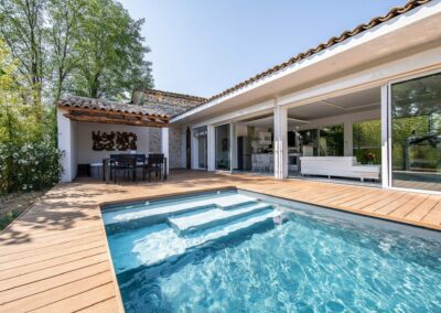 Piscine grandes marches tour bois et pool-house